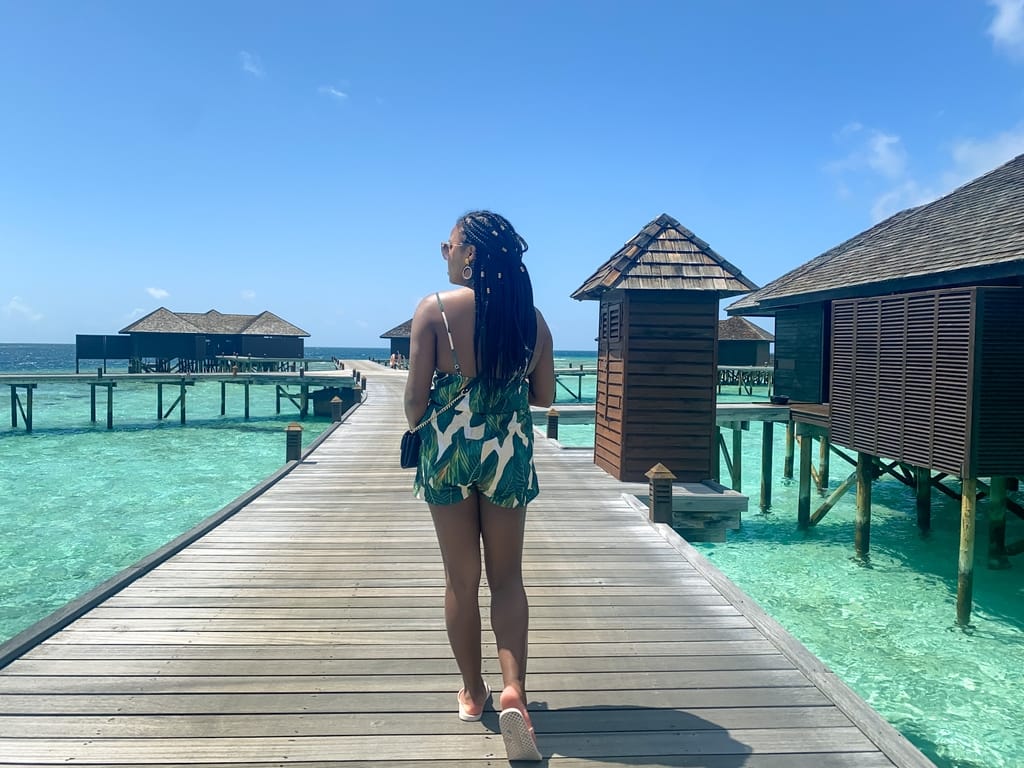 Girl walking along boardwalk in the Maldives Lily Beach Resort and Spa