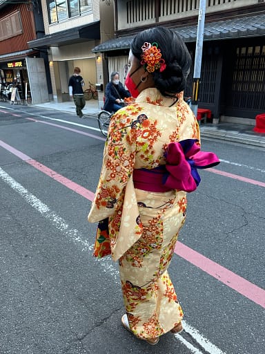 View of the back of a girl, wearing a kimono, walking along the street